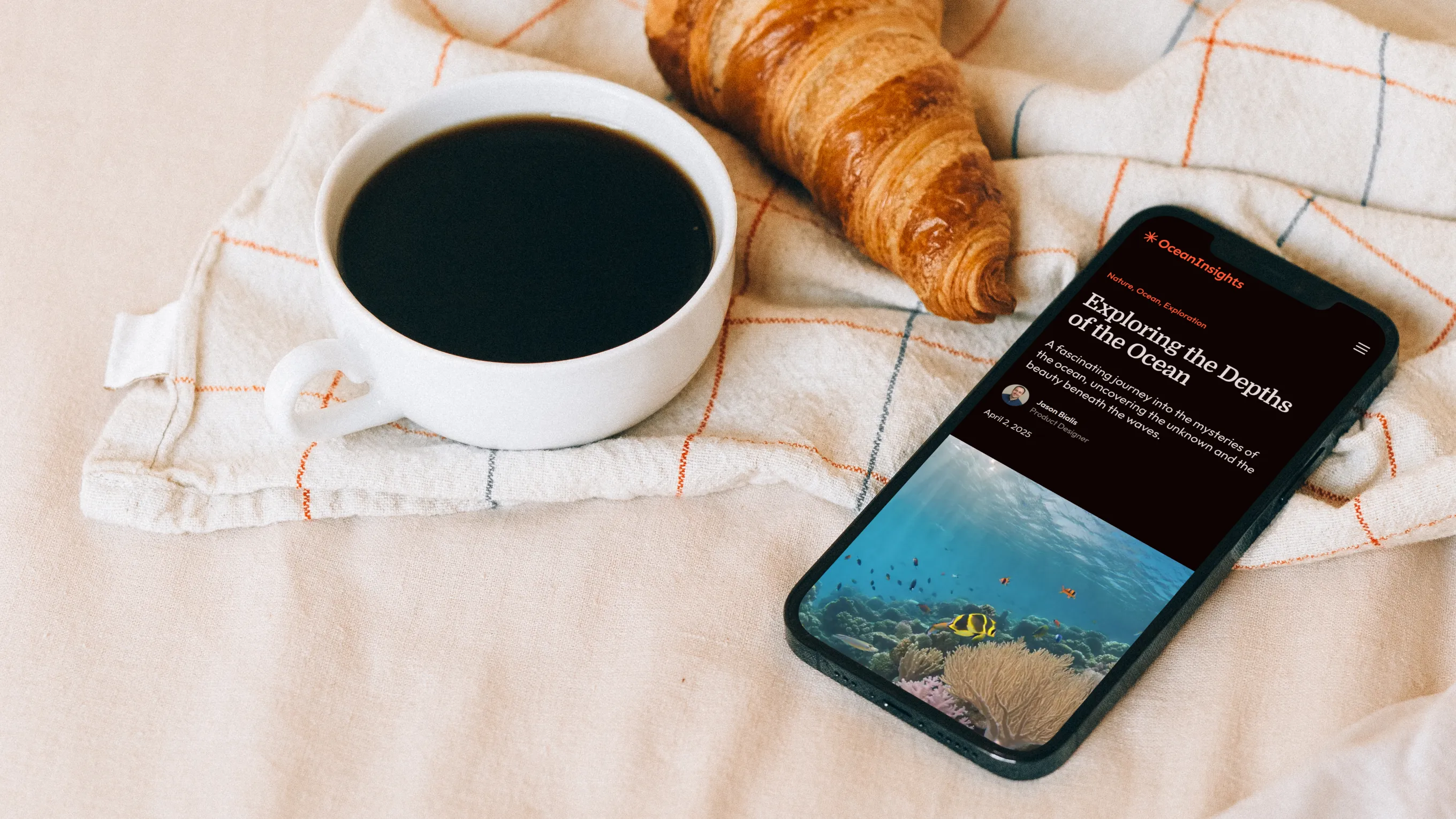 iPhone 12 Pro mockup beside a croissant and a cup of coffee